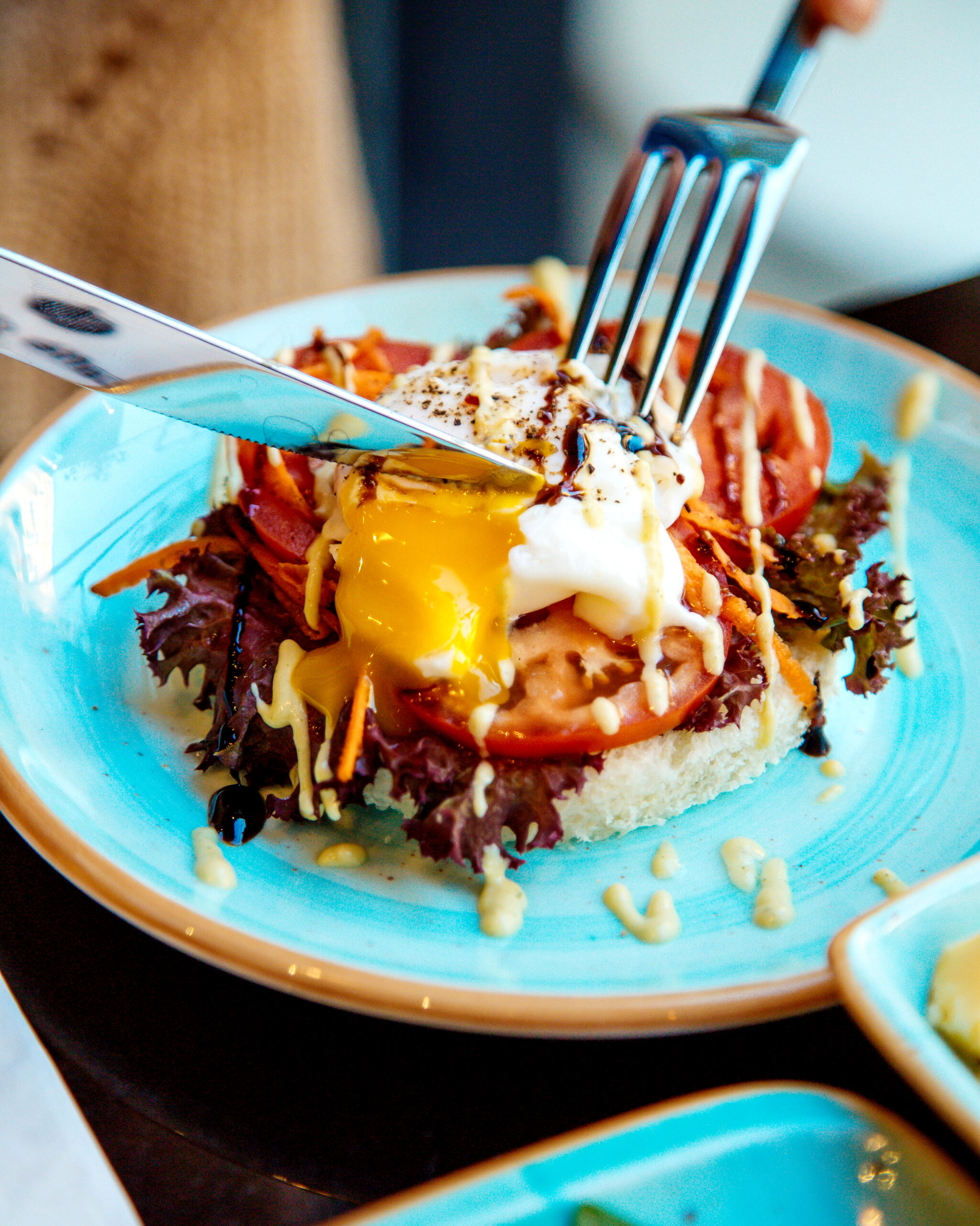sliced poached egg on tomato and crisp bread